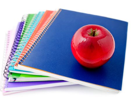 Pile of notebooks with an apple - isolated over a white background