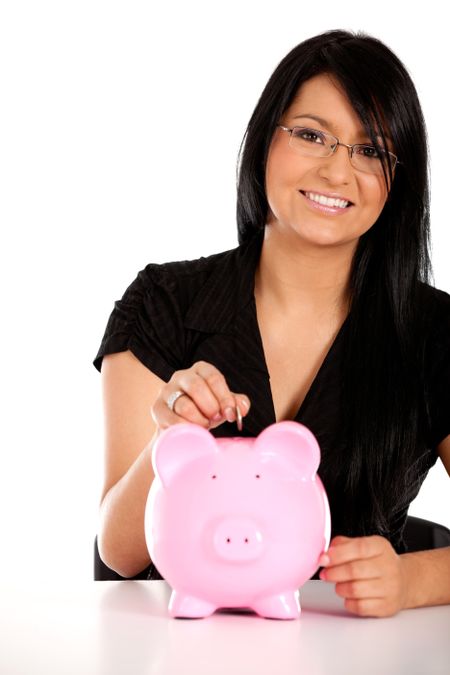 Woman putting her savings in a piggy bank ? isolated