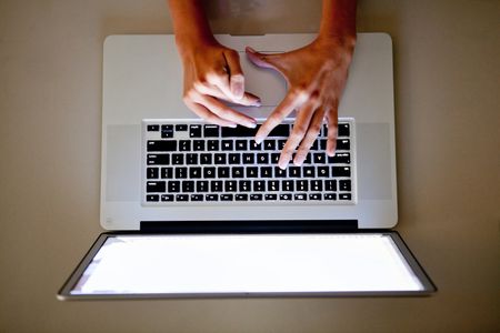 Woman's hand on the keyboard of a laptop computer