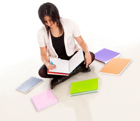 Female student sitting on the floor with notebooks around