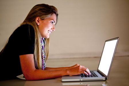 Woman looking at the screen of a laptop and smiling