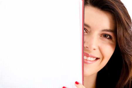 Female student covering her face with a notebook - isolated over white