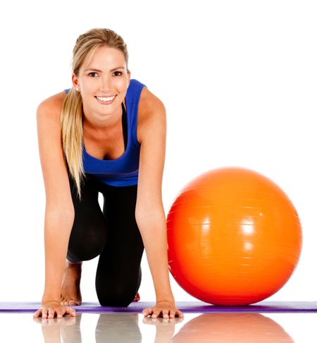 Sportive woman exercising with a pilates ball - isolated over white