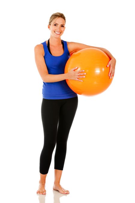 Sportive woman with a pilates ball - isolated over white