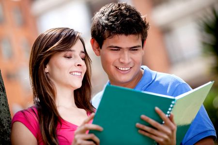 Couple of students with a notebook outdoors
