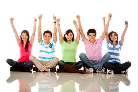 Happy group of people with arms up sitting on the floor - isolated
