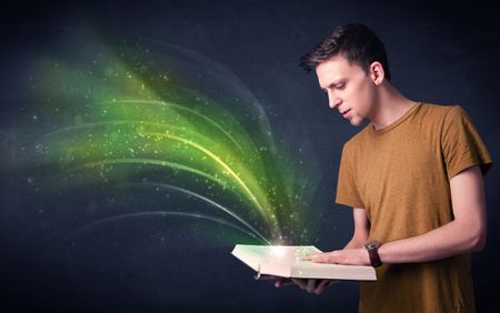 Casual young man holding book with green wave flying out of it