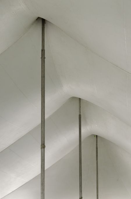 Teamwork by design: Ceiling of long tent, supported by tall poles, for spring garden sale