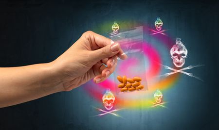 Female hand delivers illegal capsules with deathâ??s head wallpaper