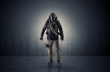 Bad agent in a dark room with arms on his hand and gas mask