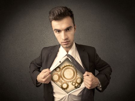Businessman tearing shirt off and machine cog wheel shows on his chest concept on background
