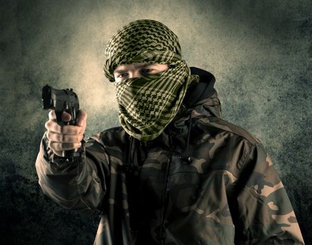 Portrait of a heavily armed masked soldier with grungy background concept