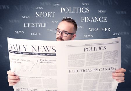 Young smart businessman reading daily newspaper