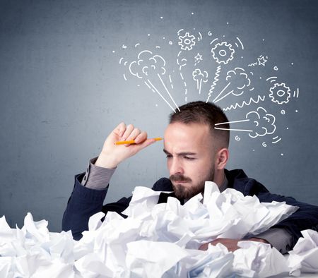 young-businessman-sitting-crumpled-paper-drawings-771746860 Young businessman sitting behind crumpled paper with drawings of gears and steam over his head