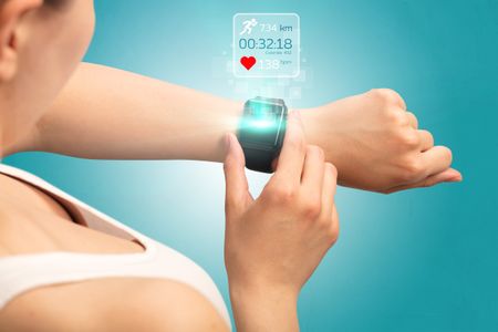 Female hand with smartwatch and running concept above.