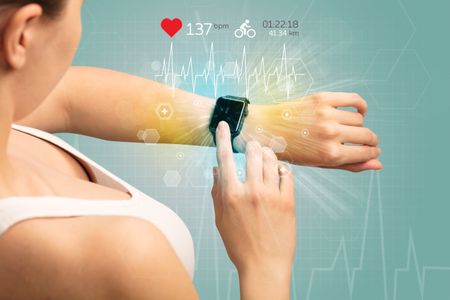 Hand with smartwatch and cycling concept nearby.