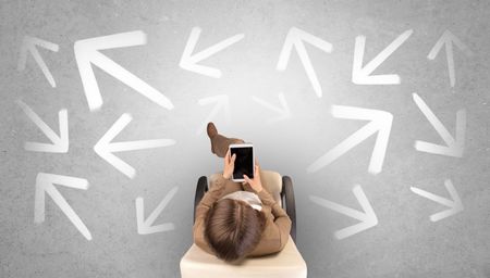 Woman sitting in office in a beige chair using device and having to choose between different choices