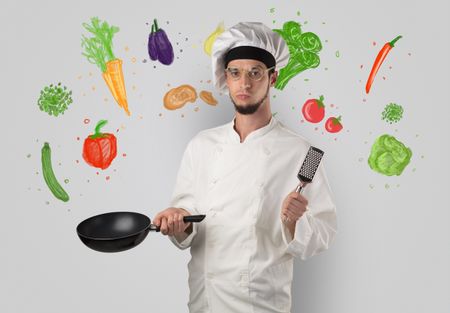 Bearded cook with colourful drawn vegetables on a white wallpaper
