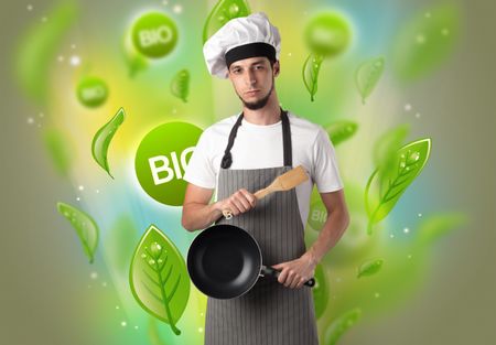 Green bio leaves concept and cook portrait with kitchen tools