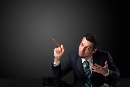 Businessman holding cigarette in his hand and wearing suit.