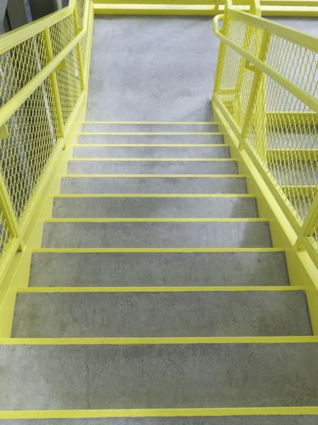 Staircase with yellow-edged steps and yellow sides in stairwell of community college