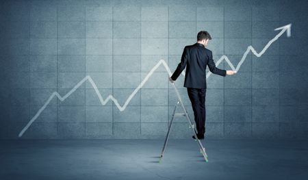 A man standing on a ladder and drawing a chart on blue wall background with exponential progressing curve, line