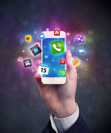 Caucasian hand in business suit holding a smartphone with colorful media icons