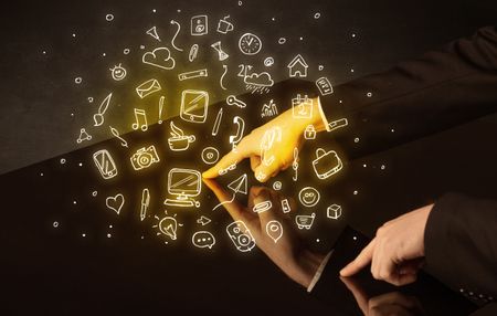 Male hands touching interactive table with yellow mixed media icons on it