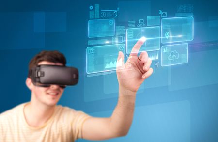 Young impressed man wearing virtual reality goggles with blue squares containing data at his fingers