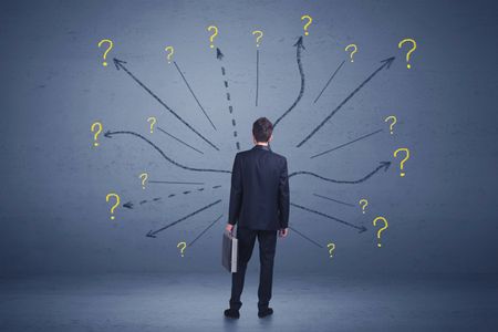 Businessman standing in front lines and question mark signs concept on background