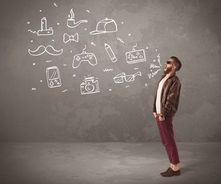 A funny hipster person in casual urban clothing shouting drawn everyday items like camera, tie or pen on city wall concept