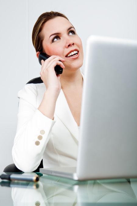 Business woman at the office talking on the phone