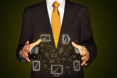Businessman holding icons related to devices and communication 