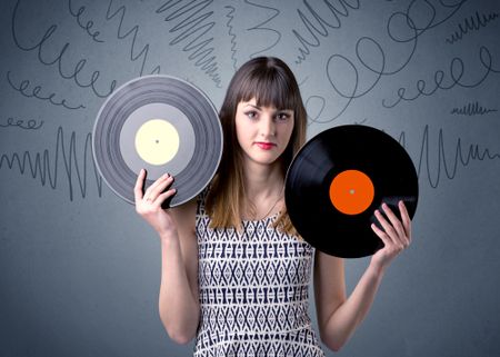 Young lady holding vinyl record on a grey background with scribbles around her