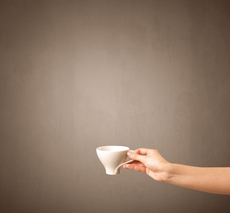 Young female hand holding coffee cup with brown background