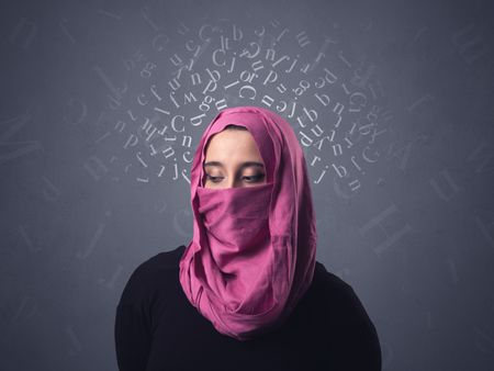 Young muslim woman wearing niqab with white alphabet letters above her head