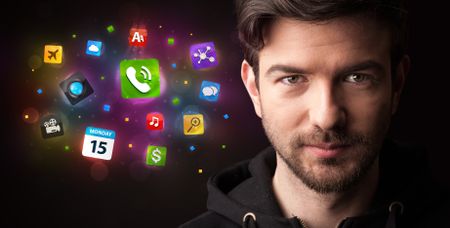 Portrait of a young businessman with colorful applications next to him on a dark background