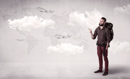 Handsome young man standing with a backpack on his back and planes in front of a world map as a background 