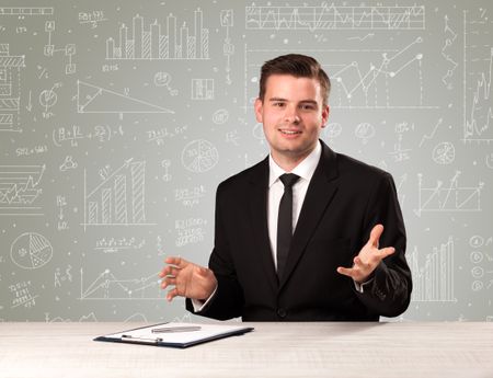 Young handsome businessman sitting at a desk with white graphs and calculations behind him