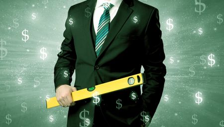 Handsome businessman holding tool with dollar symbols around and with green background