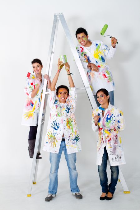 Group of painters holding their brushes and smiling on a ladder