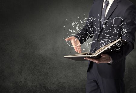 Businessman holding book with doodle drawings and signs.