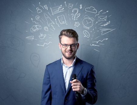 Businessman speaking into microphone with mixed doodles over his head