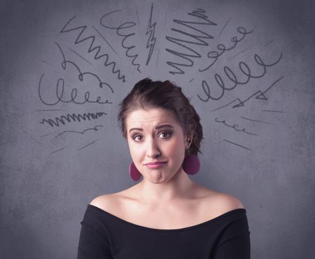 A cute female student making funny face expressions with pressure and problems in her head illustrated by drawn lines, marks and spirals on the urban wall background concept.