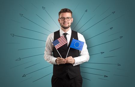 Smiling young man standing with flag and multidirectional arrows around
