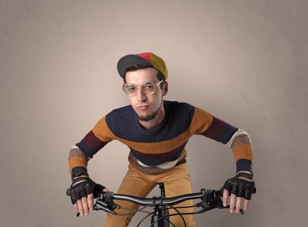 Nerd young foolish biker on a bike with oldschool outfit