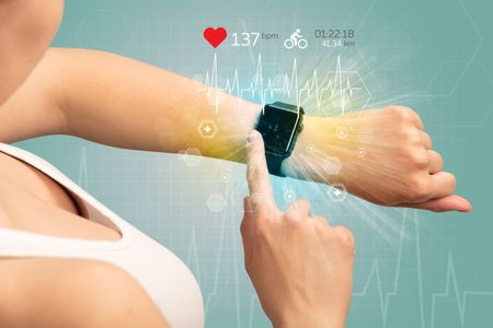 Hand with smartwatch and cycling concept nearby.