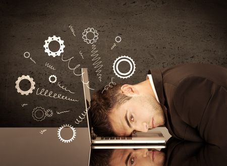 Falling apart illustration concept with cranks, cog wheels springing from a fed up and tired businessman's head resting on laptop keyboard