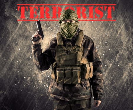 Portrait of dangerous masked and armed man with terrorist sign on grungy background