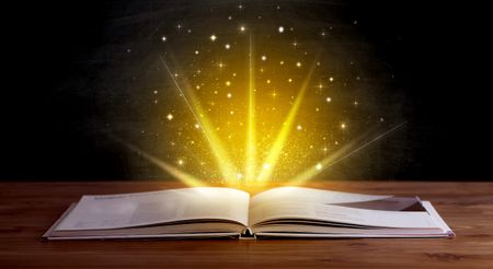 Yellow lights and sparkles coming from an open book